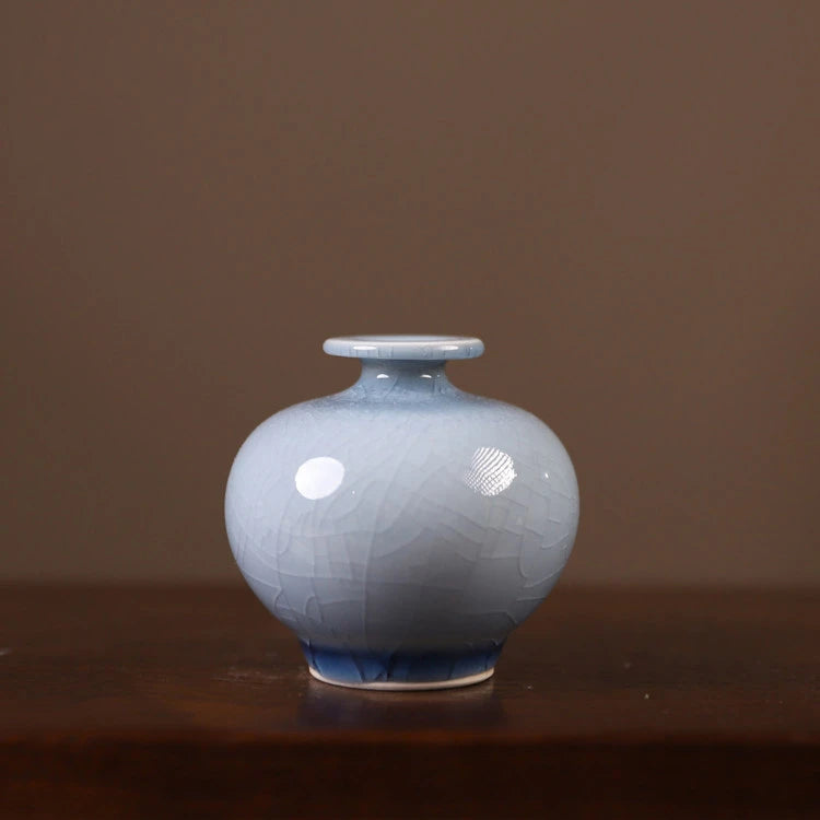Front view of a pale-blue pomegranate-form porcelain vase with crackle glaze.