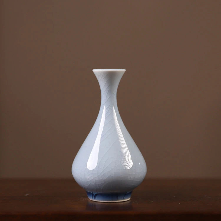Front view of a pale-blue teardrop porcelain vase with crackle glaze.