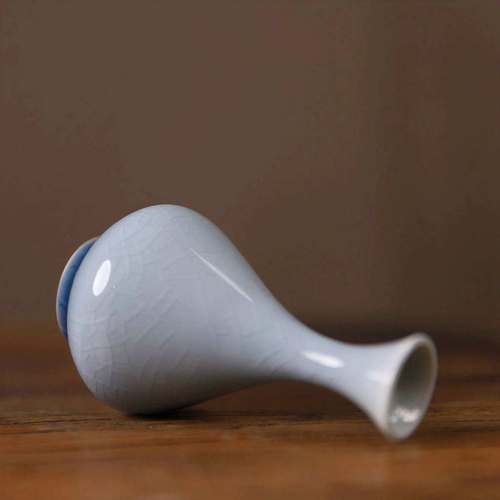 Side view of a pale-blue teardrop porcelain vase with crackle glaze.