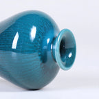 Glossy peacock green vase detail with visible mouth and foot