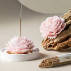Pink porcelain carnation incense holder on a restrained tea table
