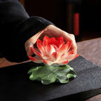 Porcelain lotus being placed onto its green lily pad base