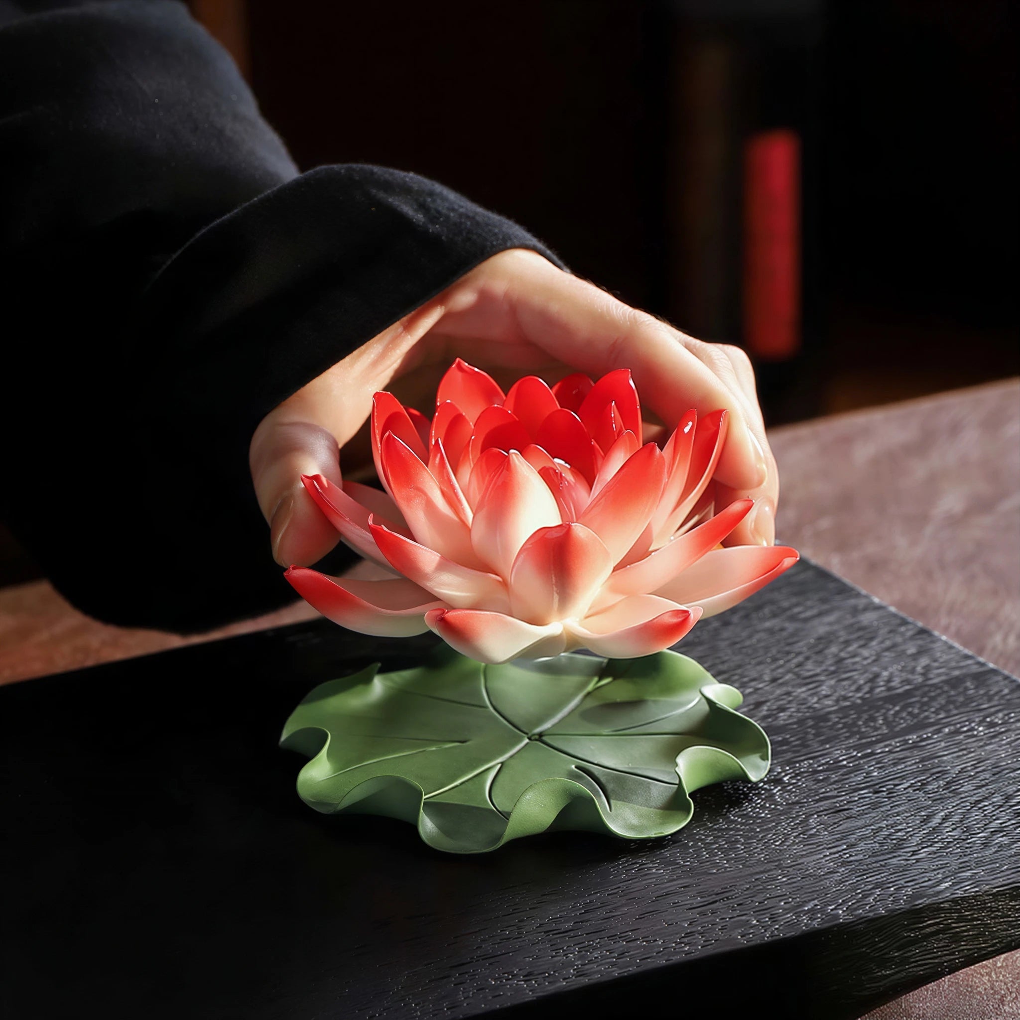 Porcelain lotus being placed onto its green lily pad base