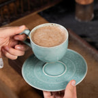 Plum Green celadon coffee cup held in hand