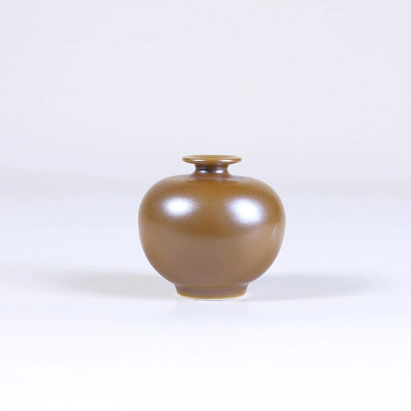 Pomegranate-form maple-yellow mini porcelain vase with a compact round body.