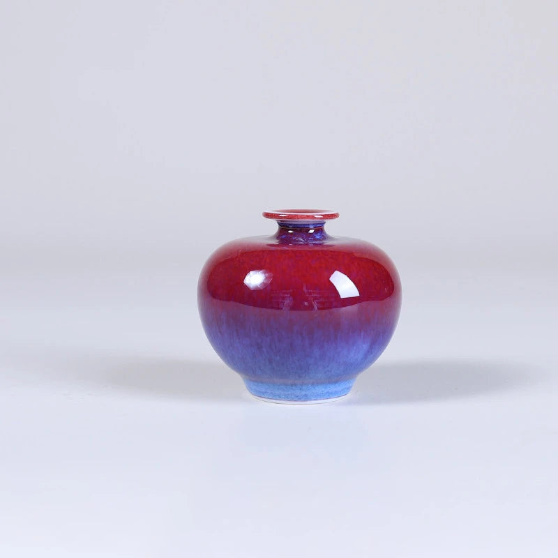 Rounded pomegranate-form rose-purple mini porcelain vase with a small mouth.