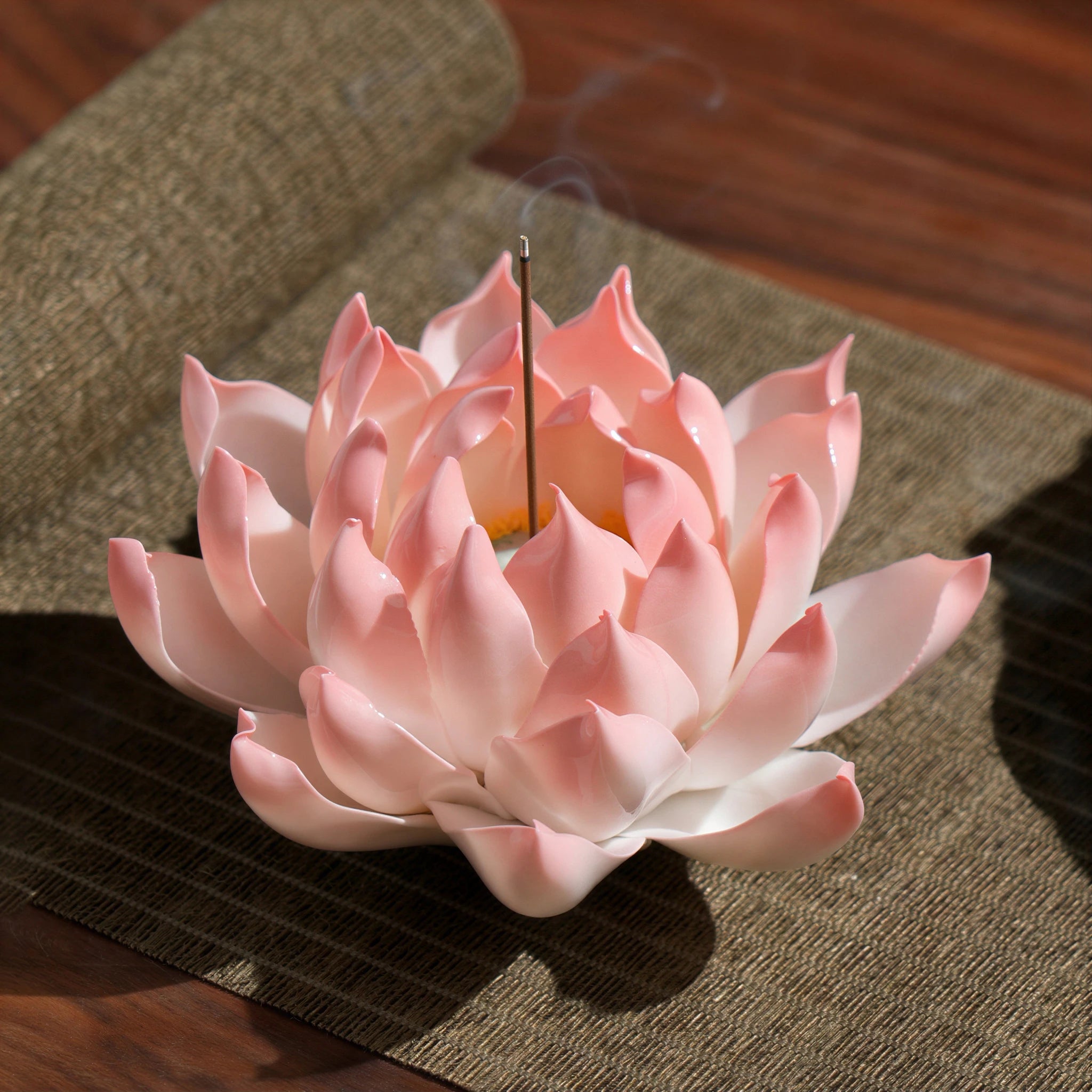 Blush pink porcelain lotus holding a single incense stick