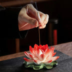 Incense stick being placed into the porcelain lotus center