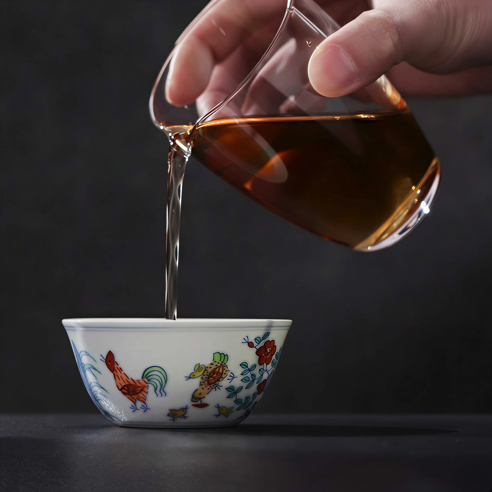 Tea being poured into a hand-painted doucai chicken cup