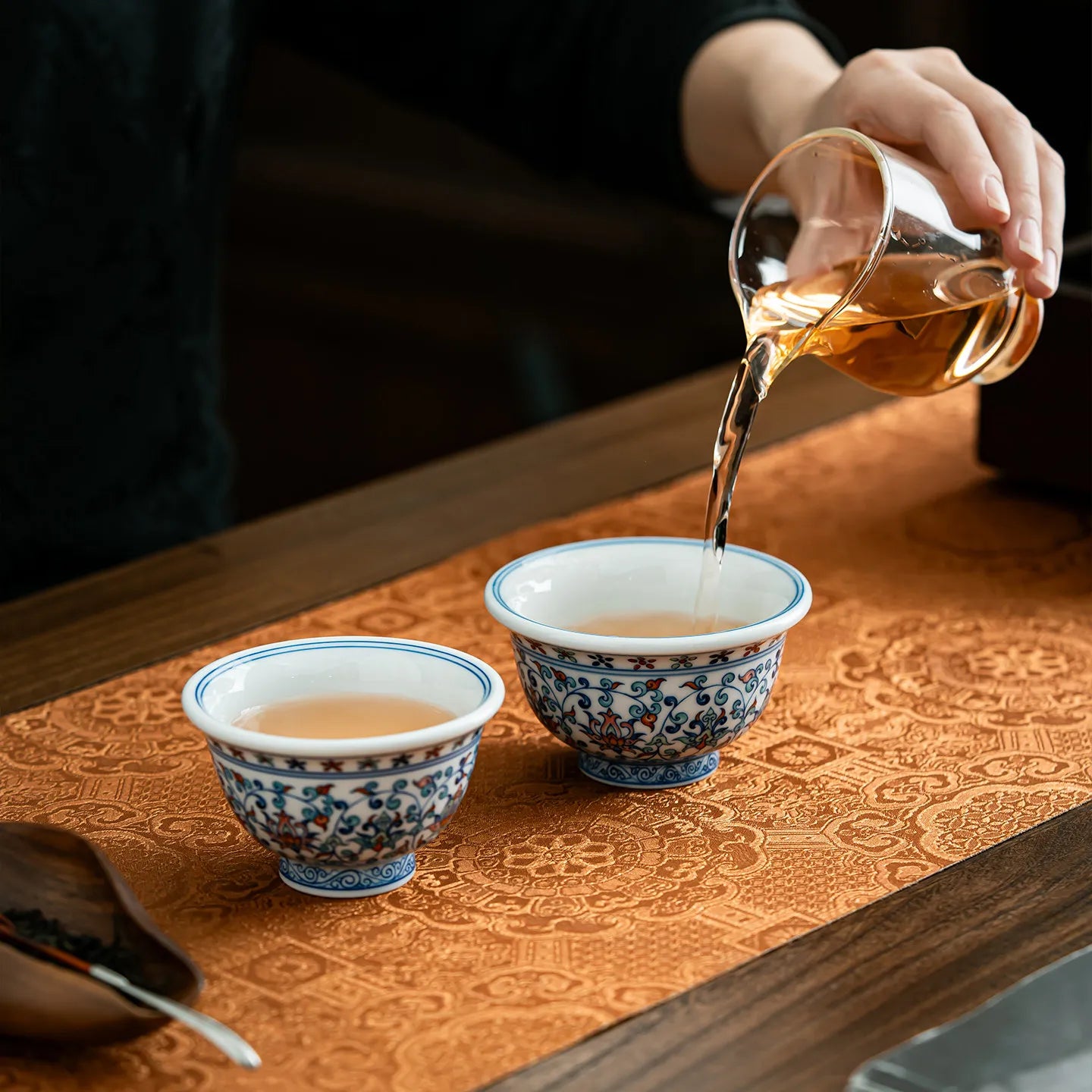 Tea being poured into the two doucai-inspired press-hand cups