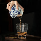 Tea being poured from the wood-fired scrolling lotus gaiwan