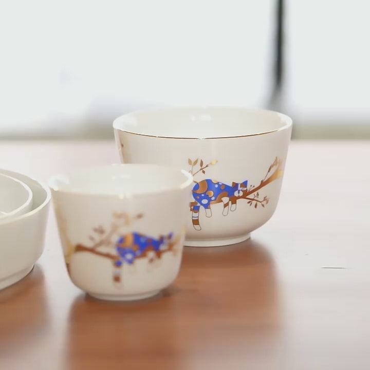 Close video of the Jingdezhen Forest Rest five-piece porcelain tableware set with a blue resting cat and gold branch decoration.