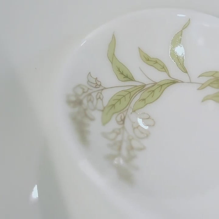 Video of the Jingdezhen Spring Dawn eleven-piece porcelain dinnerware set, showing its botanical decoration, bowl profiles, condiment dishes, spoons, and silver-colored rims.