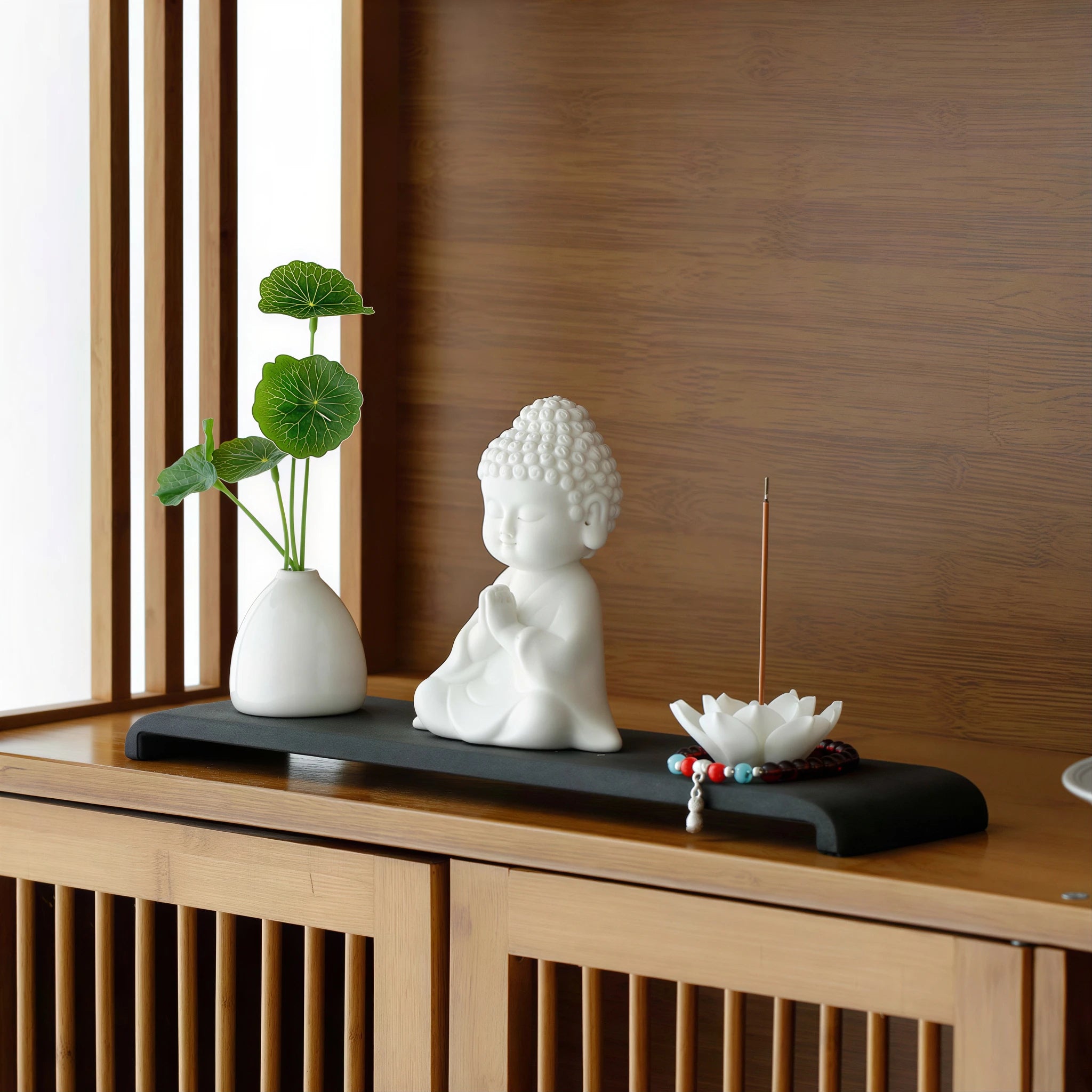 White porcelain Buddha altar set displayed on a cabinet