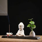 Angled view of the seated Buddha, lotus holder and vase