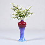 Tall rose-purple meiping vase holding a small leafy branch.