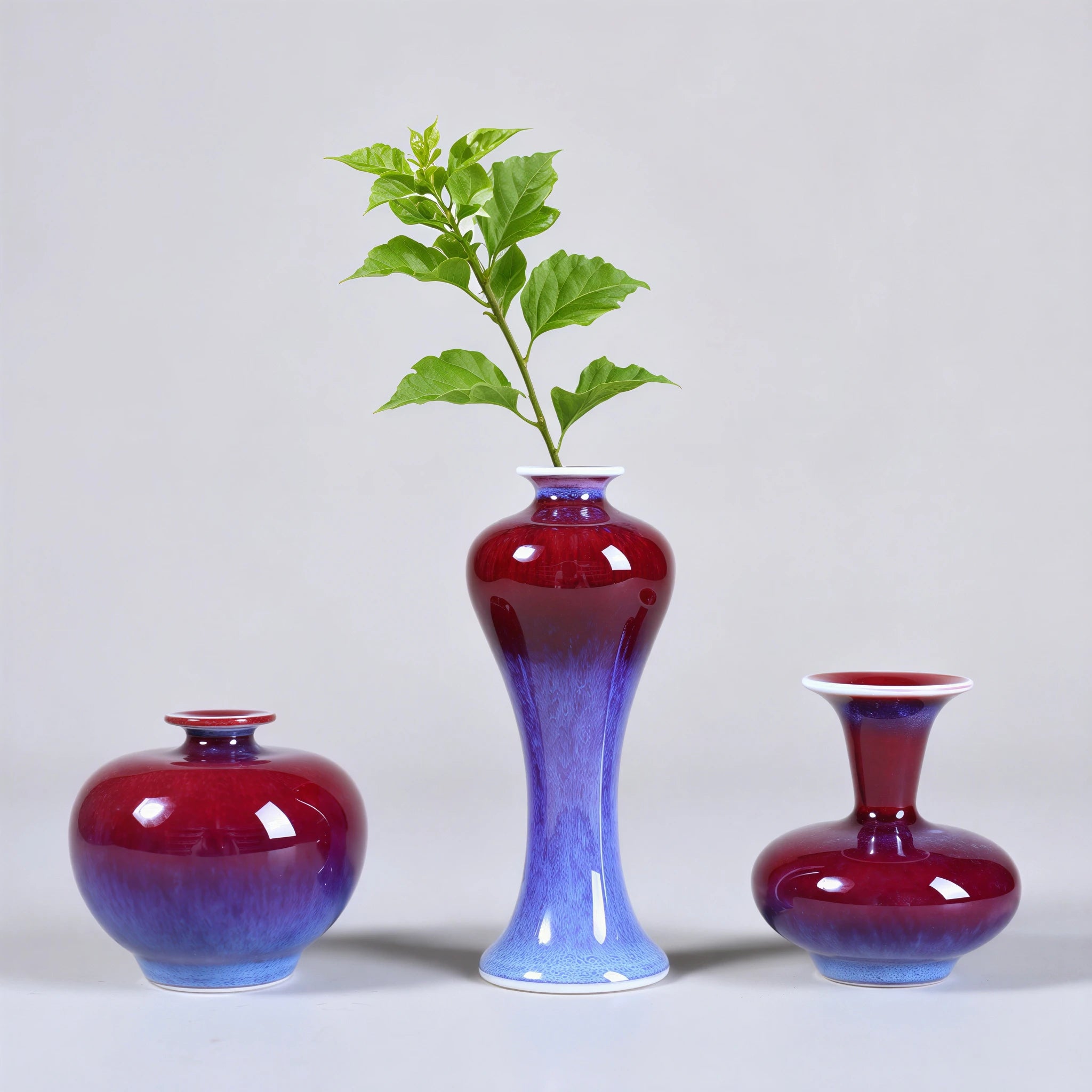 Three rose-purple mini porcelain vases arranged with green cuttings.