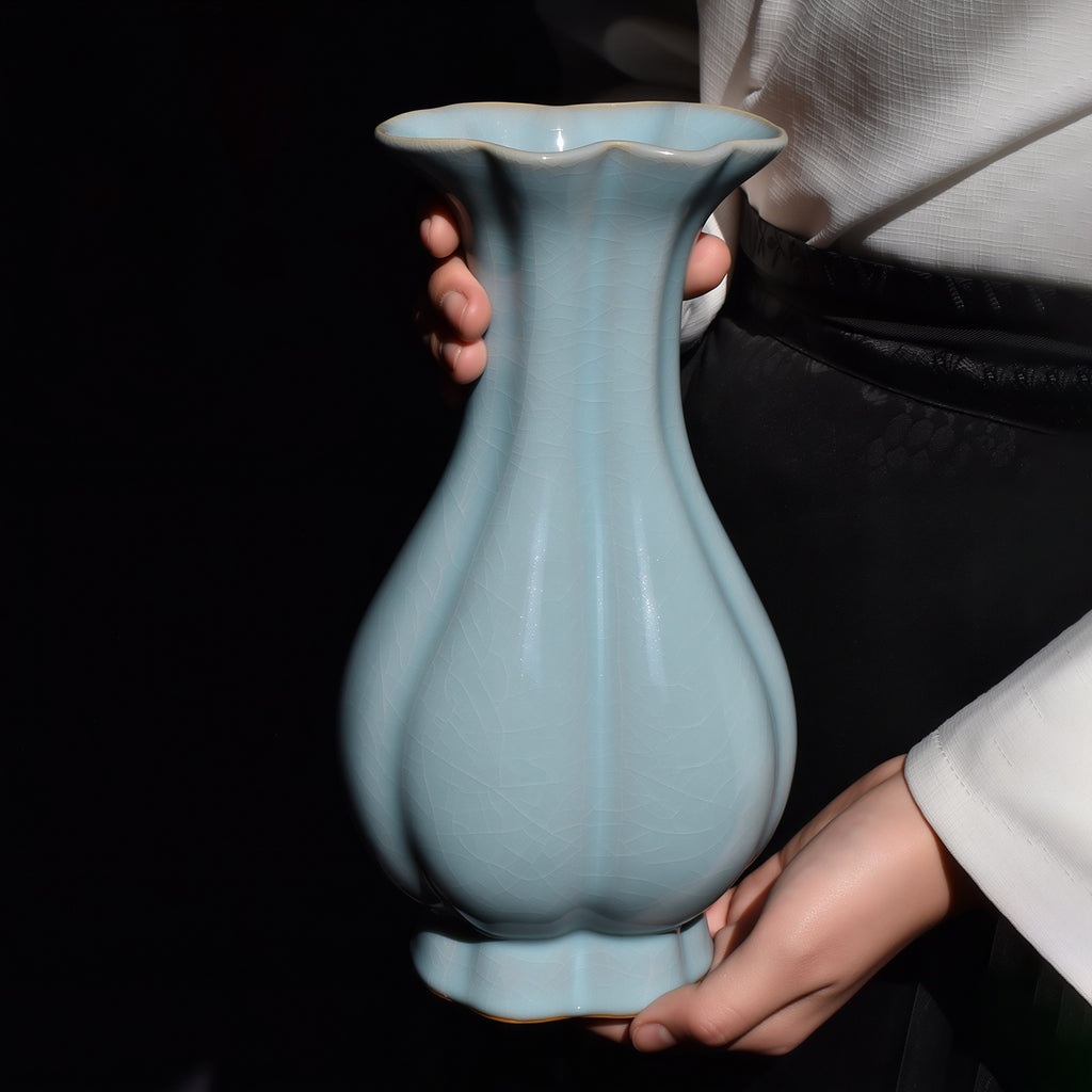 Sky-blue Ru ware Haitang vase held upright, showing its lobed body, slender neck and scalloped rim.