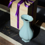 Pale blue Haitang vase beside a wooden presentation box tied with a purple ribbon.