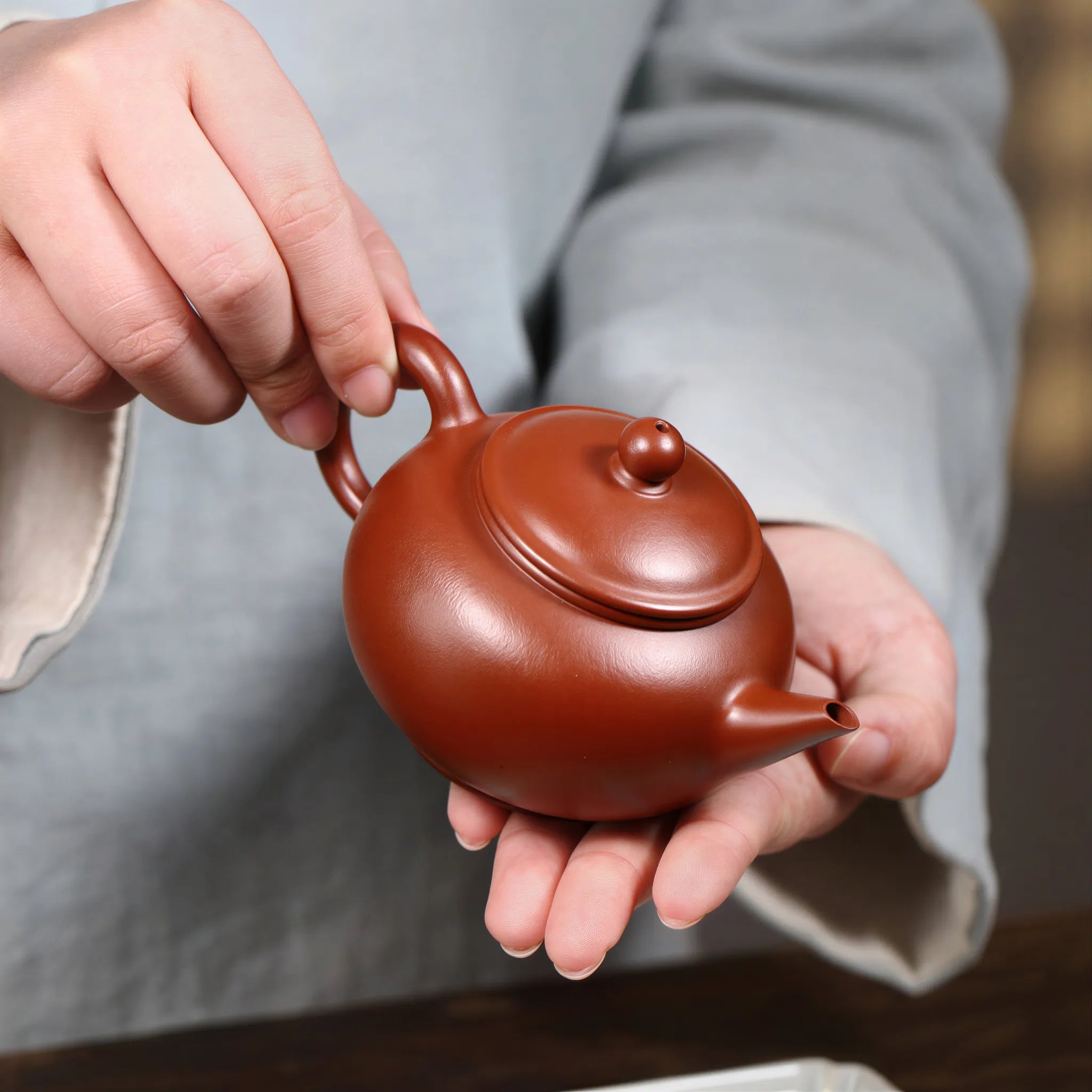 Rounded 200 ml Shui Ping teapot held in one hand
