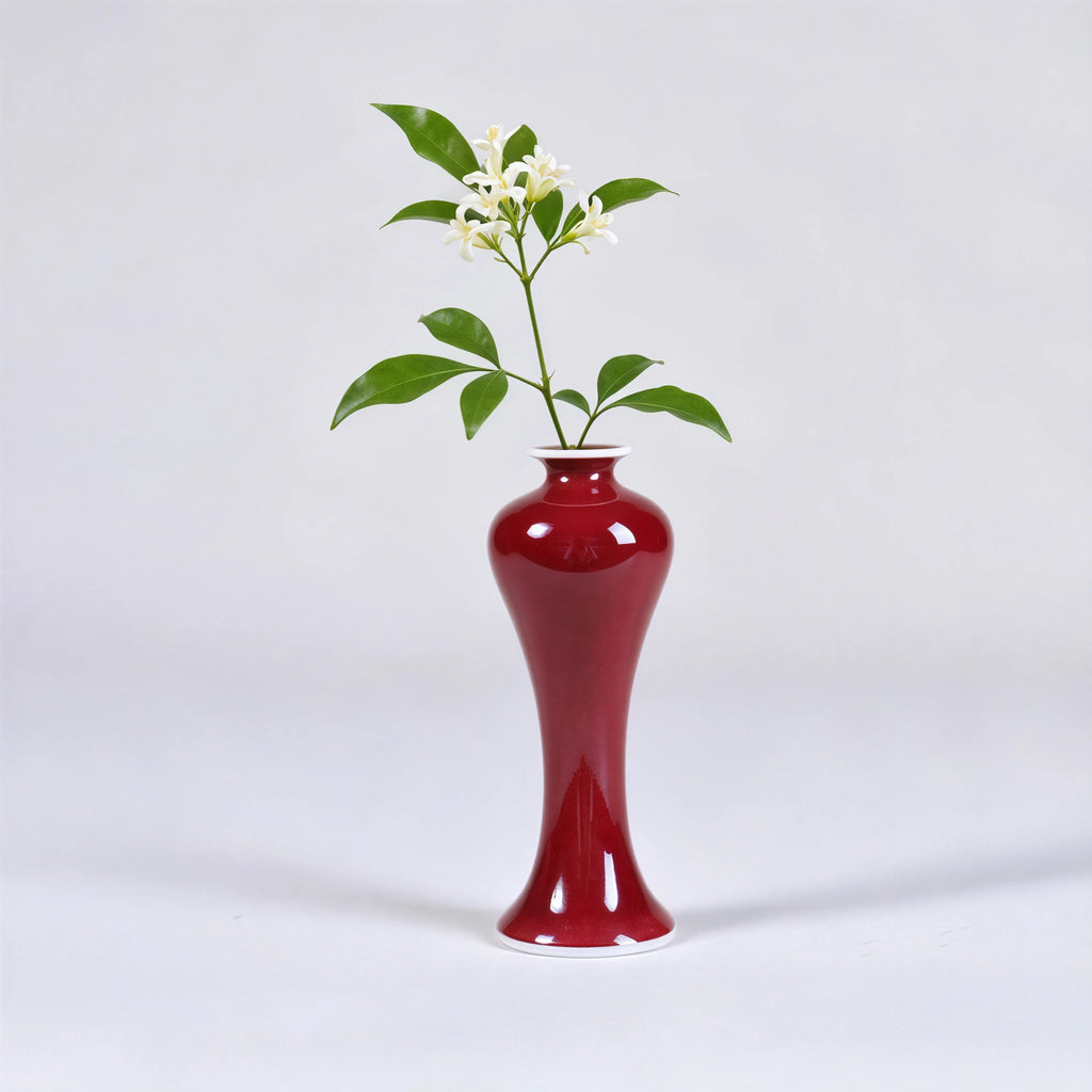 Slender oxblood red porcelain vase with a green stem