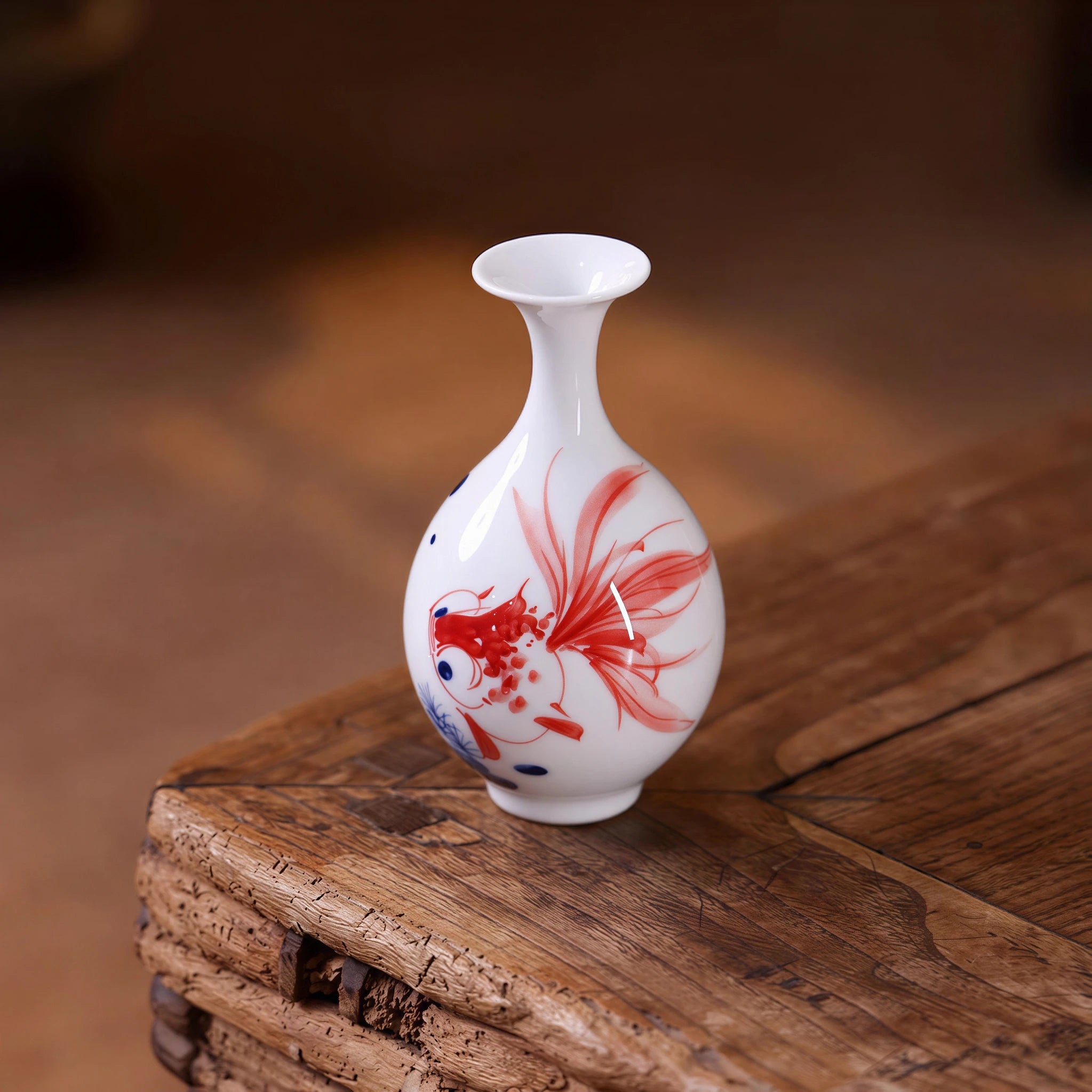 Jingdezhen hand-painted goldfish Yuhuchun mini vase on a wooden surface