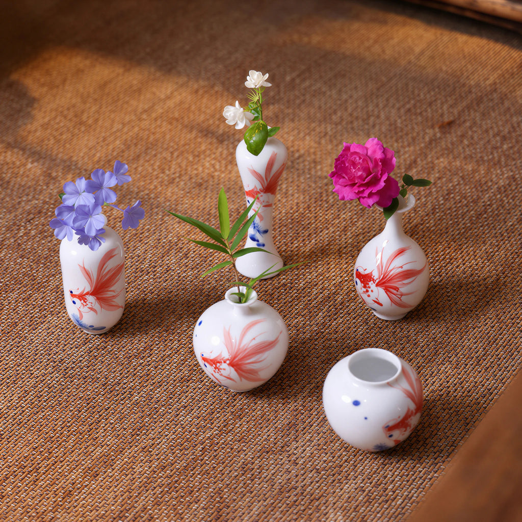 Small-scale hand-painted goldfish porcelain vases arranged on fabric