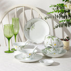 Jingdezhen Spring Dawn porcelain dinnerware displayed with botanical bowls, plates, condiment dish, and silver-colored rim details.