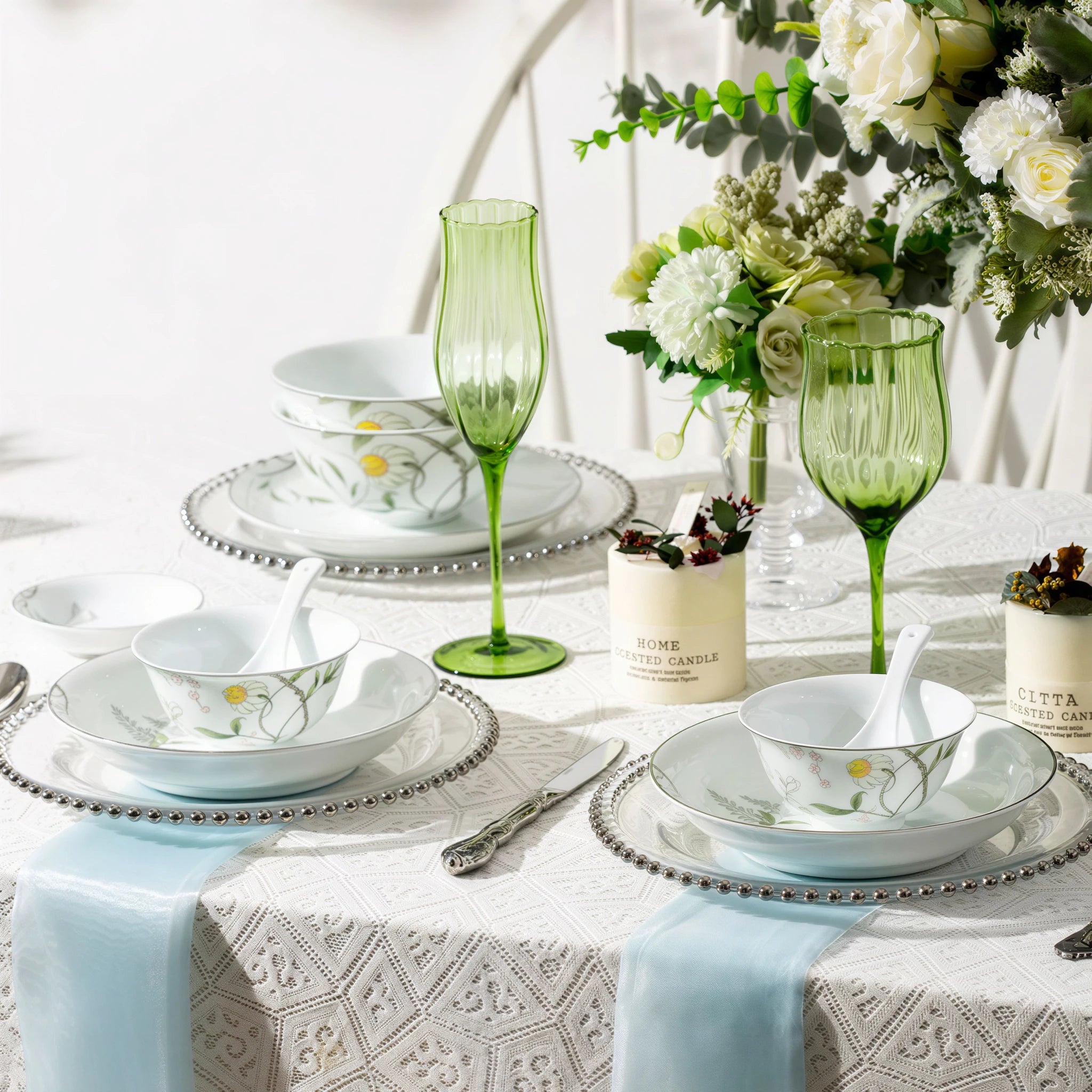 Spring Dawn porcelain plates and bowls arranged for two on a white table with green stemware and floral styling.