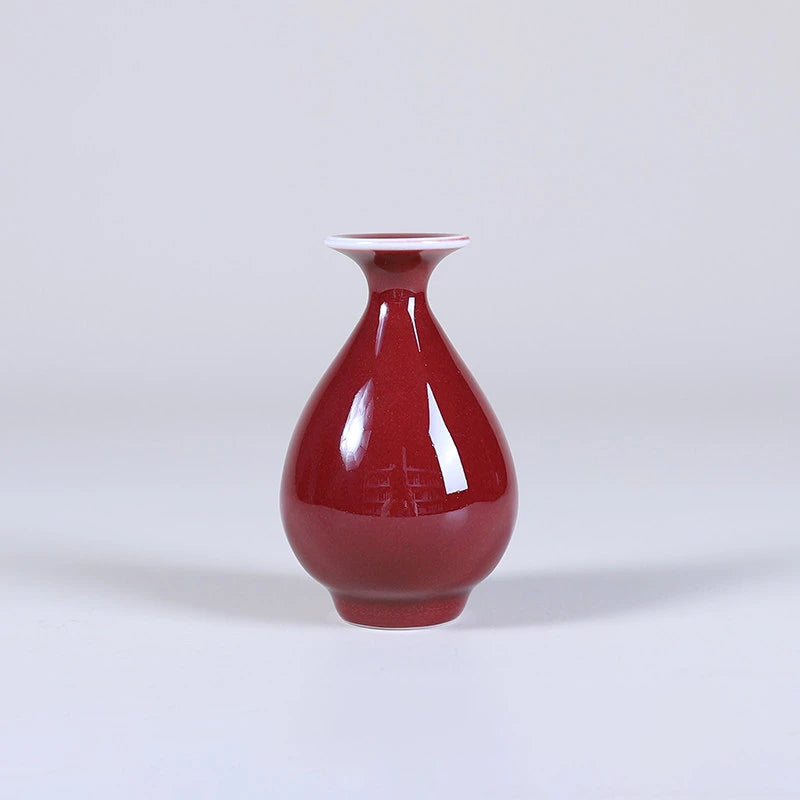 Slender teardrop oxblood red porcelain vase with flared mouth