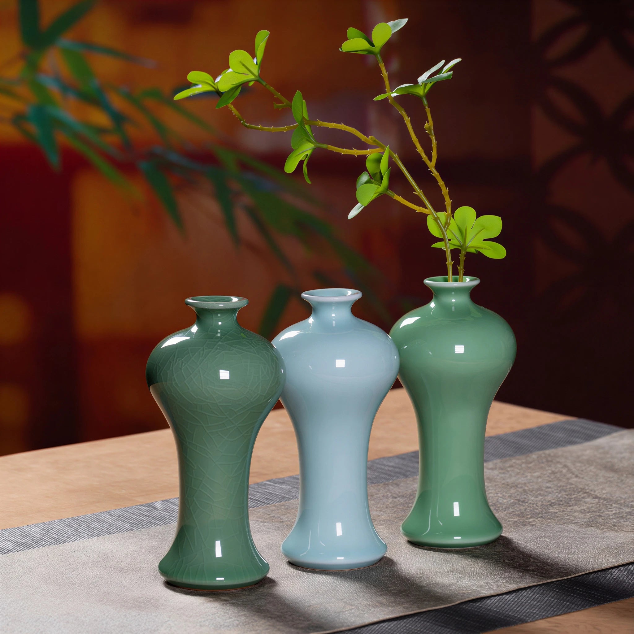 Three Longquan celadon bud vases shown with a green branch