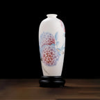 Front view of a translucent white porcelain Meiping vase with pink and blue hydrangeas