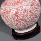 Underglaze-red botanical and border decoration across the porcelain body