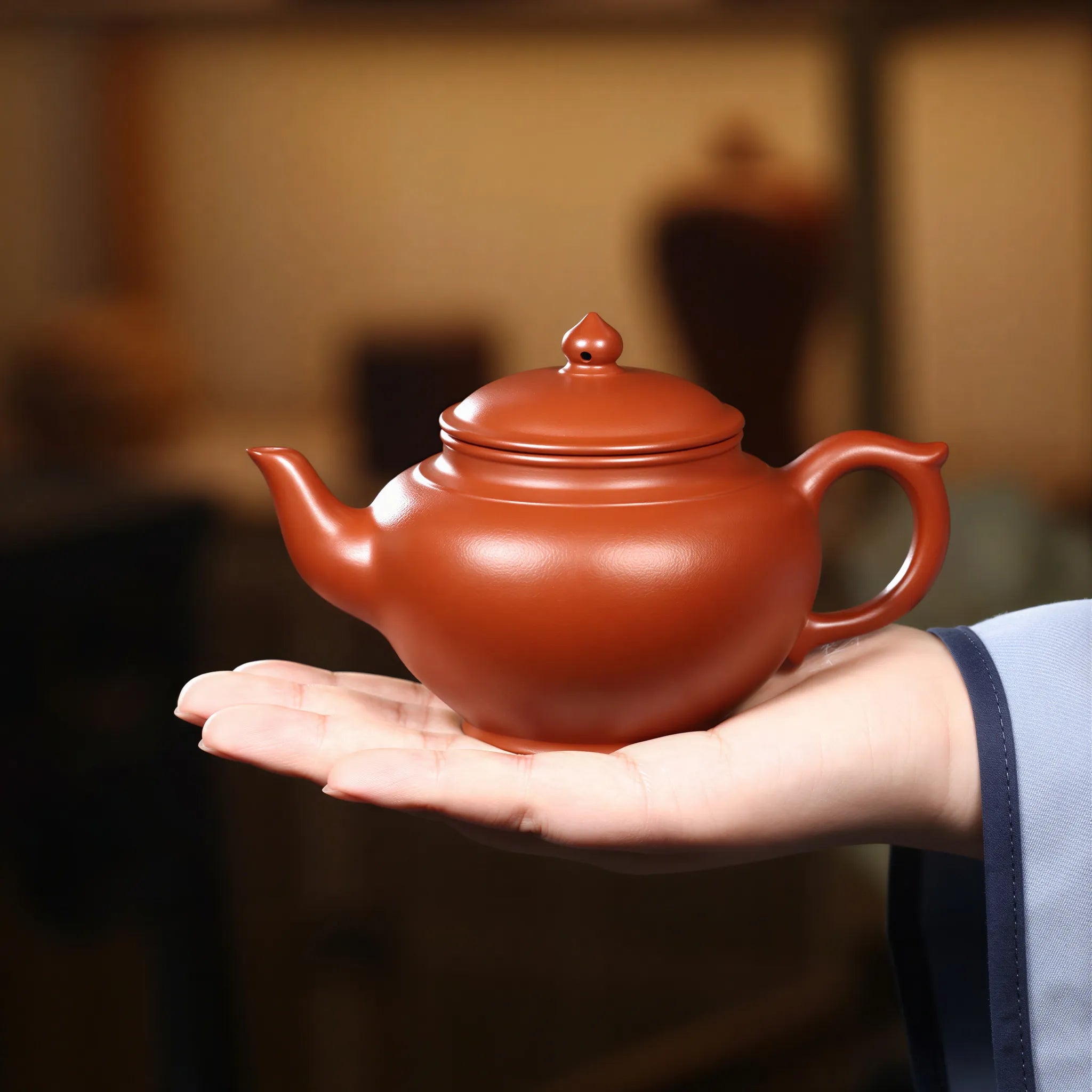 Rounded Xiao Ying teapot held in one hand for scale