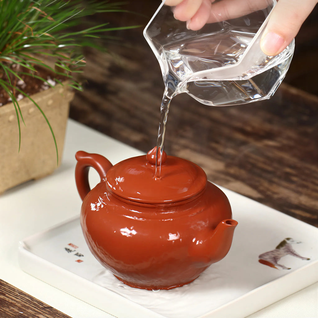 Warm water being poured over the red Xiao Ying teapot