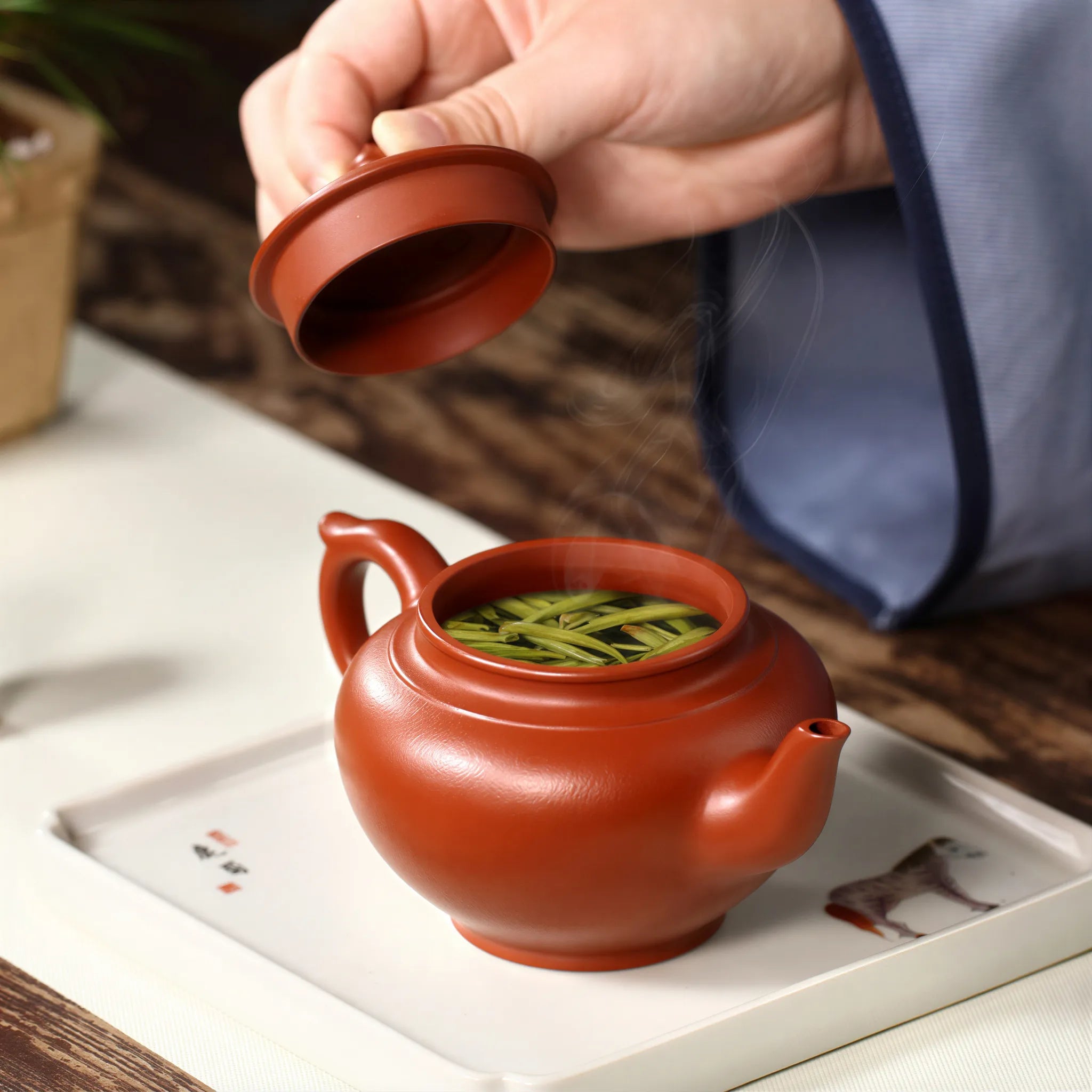 Fitted lid being lifted from the Da Hong Pao teapot