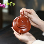 Top view of the broad 170 ml Xu Bian teapot held in one hand
