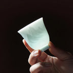 Backlit Yingqing porcelain tasting cup showing pale translucency
