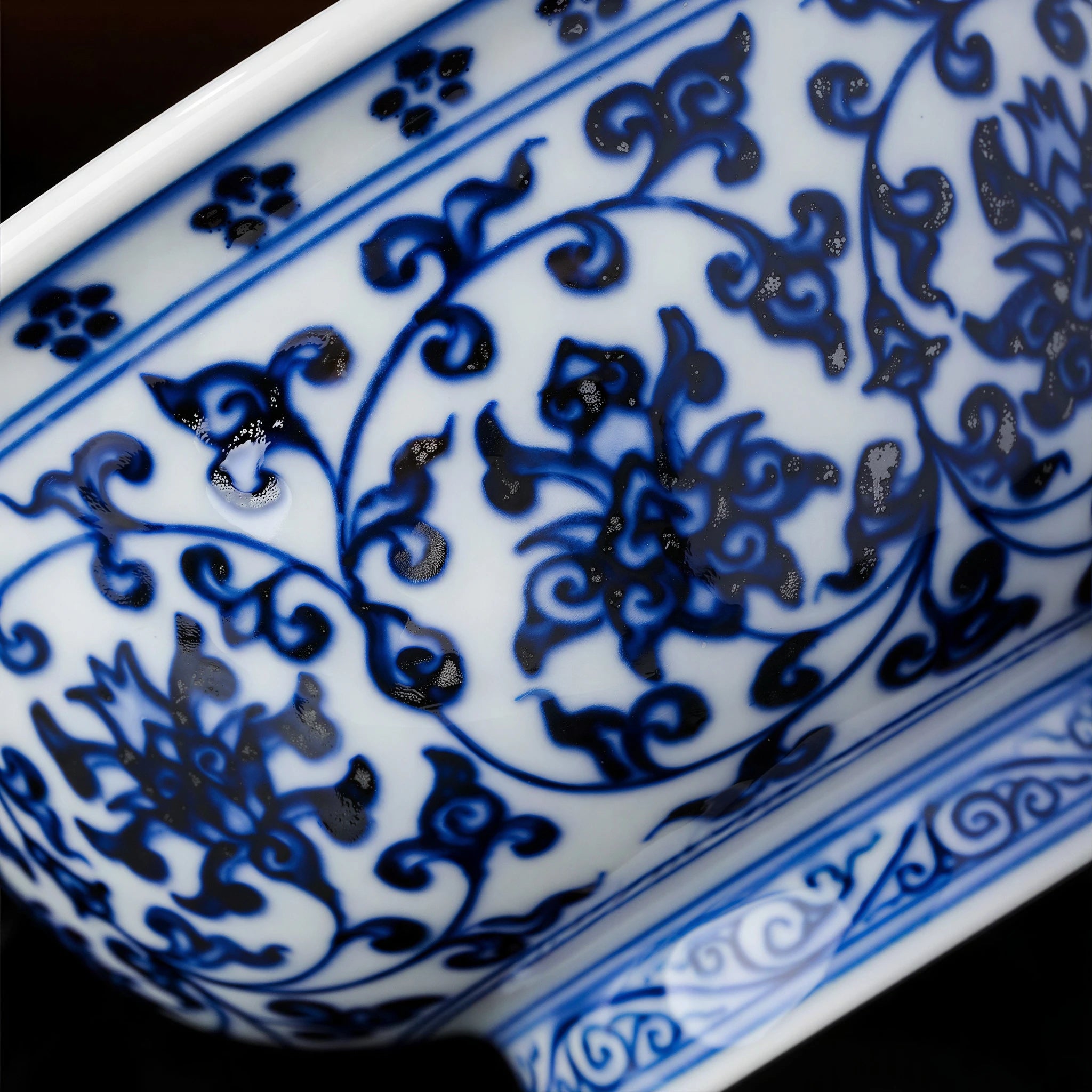 Close view of cobalt lotus scrolls and darker pigment gathering