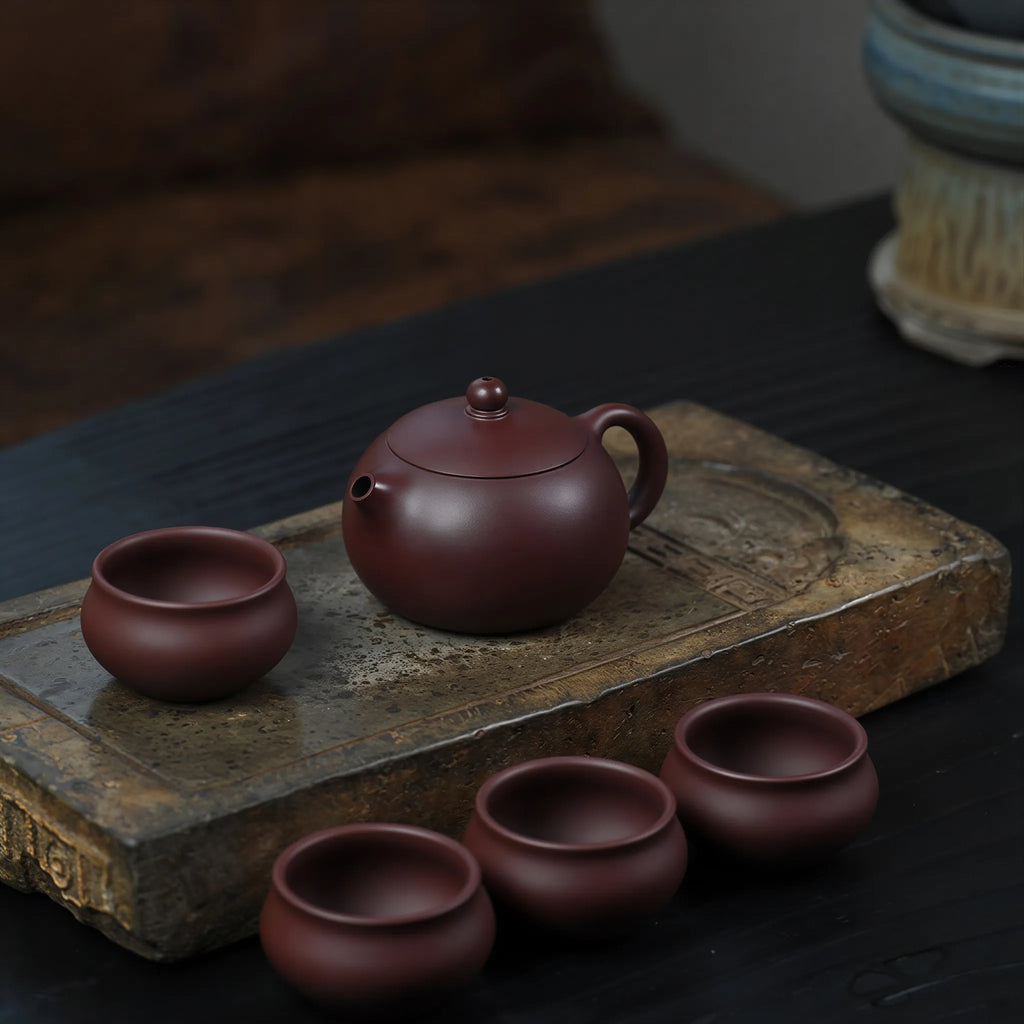 Xishi teapot arranged with four matching tasting cups